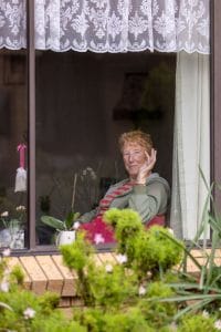 Older man waving through window
