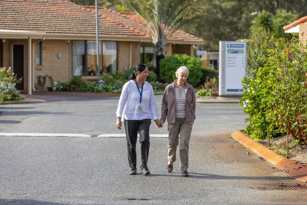 Two women walking outside retirement homes